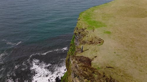 Arc Shot Of A Man Standing On A Cliff In Iceland