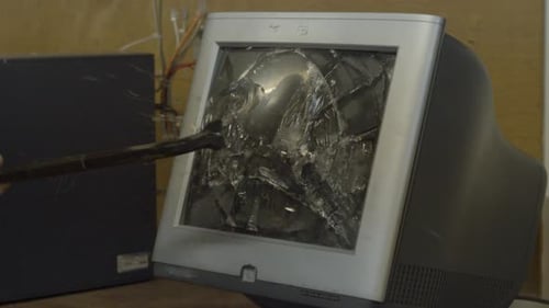 Old computer monitor being smashed with crowbar - slowmotion