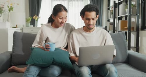 Couple Using Laptop Together on Couch at Home