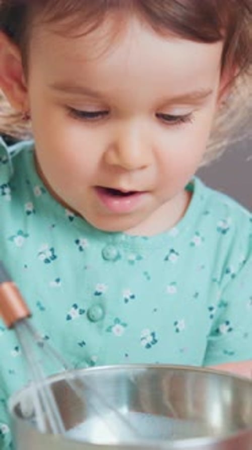Young Girl Shows Wrist Control Toddler Carefully Uses Wrist Strength to Mix Ingredients in Bowl