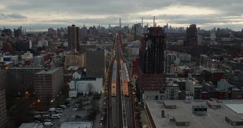 Drone shot over the Harlem 125th Street station, towards the Manhattan skyline, cloudy evening in NY