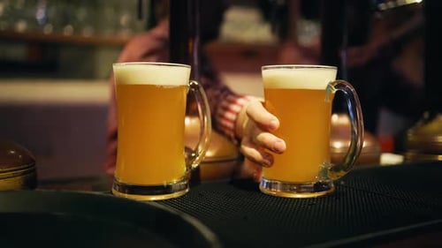 Beer Pouring Action Bartender Fills a Glass with Bubbles in a Closeup View