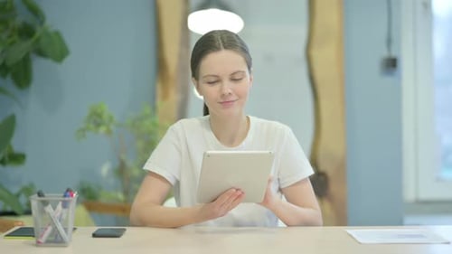 Woman Using a Tablet at a Desk