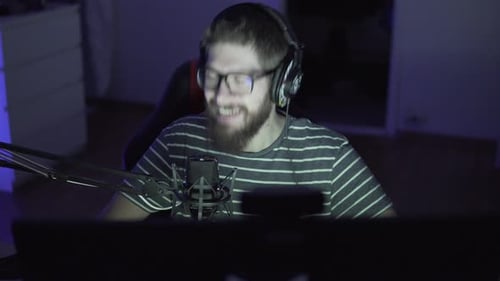 Man Gaming and Streaming Indoors at Night