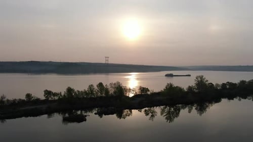 Aerial footage of a long barge floating on a river in the morning, 4k