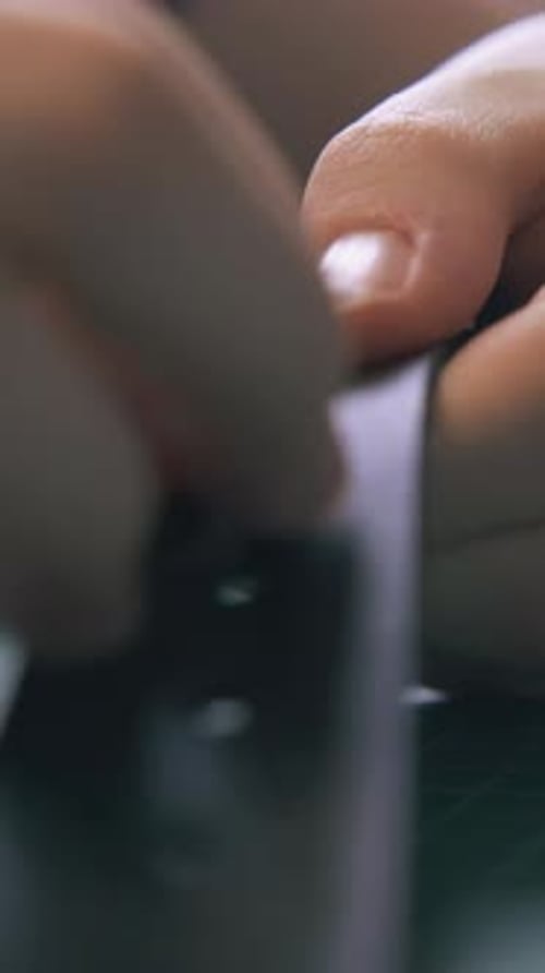 Craftsperson Adds Eyelets to a Black Leather Strap