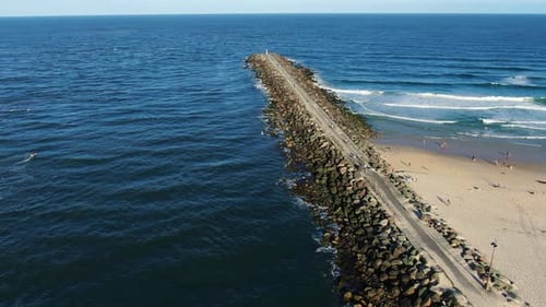 Panning right looking out over rock wall and sand pumping jetty sunset,Gold Coast