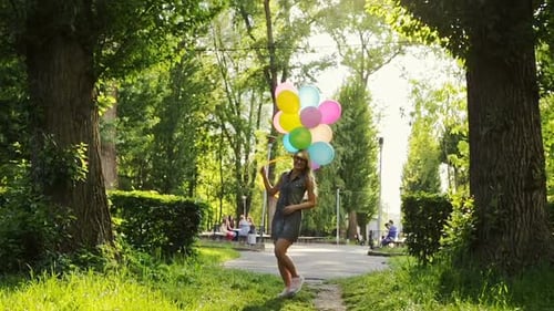 Beautiful Young Girl Having Fun at the Summer Park with Colored Balloons
