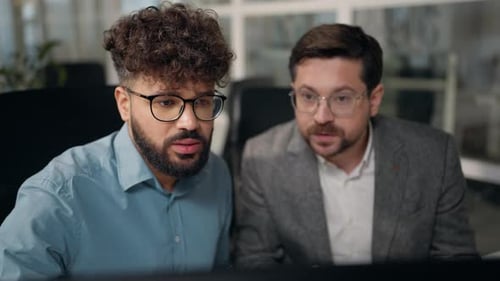 Two Men Working on a Computer in Office