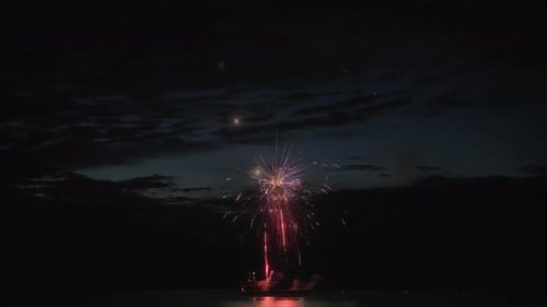 Abstract shot of exploding fireworks above the lake at night. Long exposure.