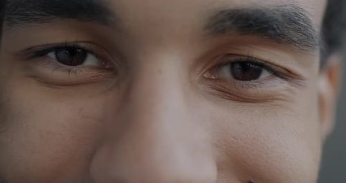 Closeup Portrait of Male Eyes Looking at Camera with Joy While African American Man Feeling Happy