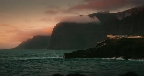 Rocky Beach Landscape with Dark Ocean Water Waves at Summer Golden Hour Los Gigantes Cliffs and