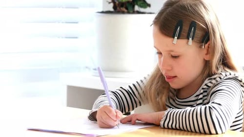 The Sweet Girl Writes Carefully and Intently at Home at the Table Elementary School Education