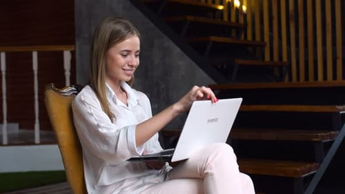 Woman working on laptop while sitting in chair