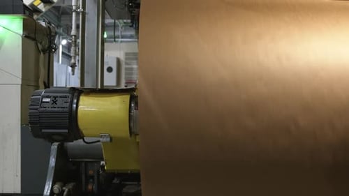 Large Paper Roller Turns on Rod in Production Plant Workshop