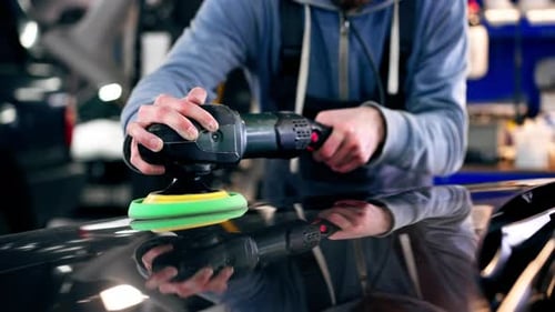 Closeup of the Hands of a Car Mechanic at a Service Station Doing the Final Polishing to Shine