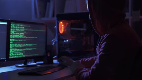 Homem hacker irreconhecível usando capuz digitando o título no teclado do computador e decifrando a senha.