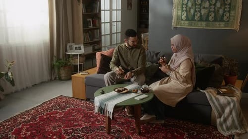 Muslim Couple Enjoying Tea and Conversation in Traditional Home