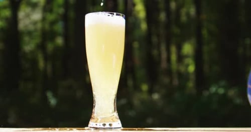 Refreshing Beer Pouring into Glass in Nature