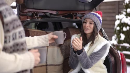 Woman Drinks Coffee in Trunk of Car Winter