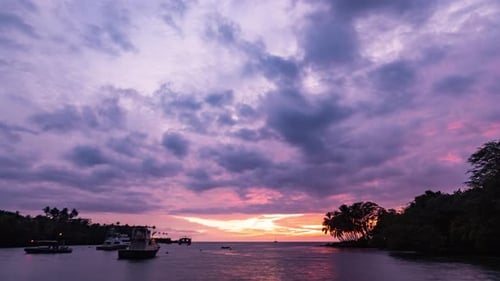 Timelapse - Beautiful sunset clouds over the ocean with sailboats in Hawaii