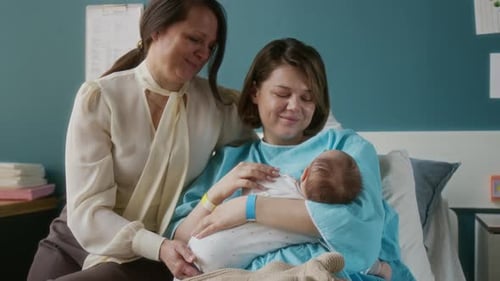Loving Couple Admiring Newborn Baby in Hospital Bed