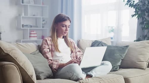 Young woman working from home taking a break and stretching