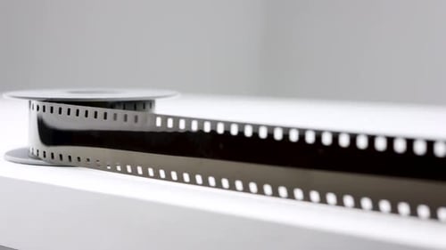 Sliding shot of 8mm old vintage film on wite table in studio