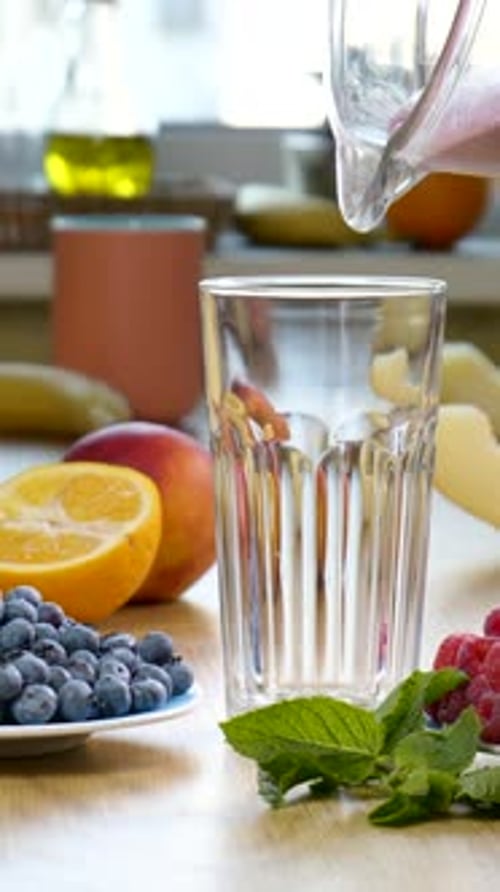 Pouring Fruity Smoothie into Glass with Berries