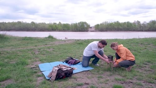People Assembling Object Outdoors near River