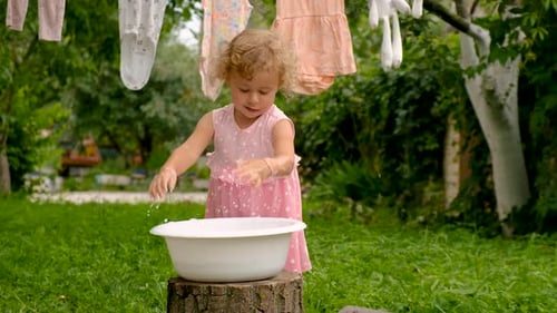The Child is Washing Clothes in the Garden Selective Focus