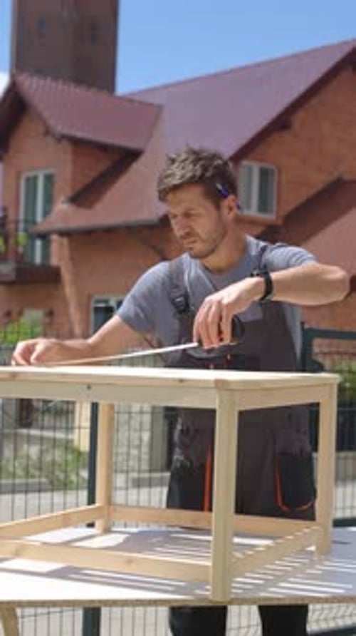 Man Assembling Wooden Terrace Furniture Outdoors