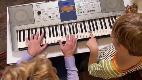 Child and Adult Playing Piano Together