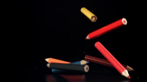 Colorful Pencils Falling onto a Black Reflective Surface