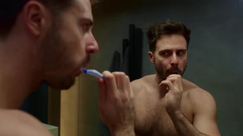 Man brushing teeth in the domestic bathroom