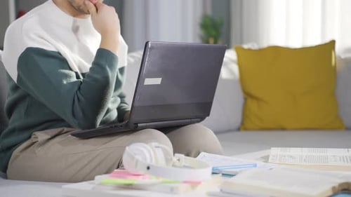 Young Adult Works on Laptop at Home