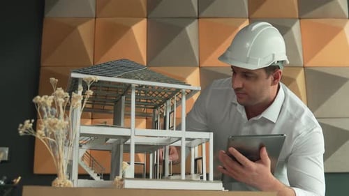 Gros plan d'un ingénieur caucasien professionnel inspectant un modèle de maison. Manipulateur.