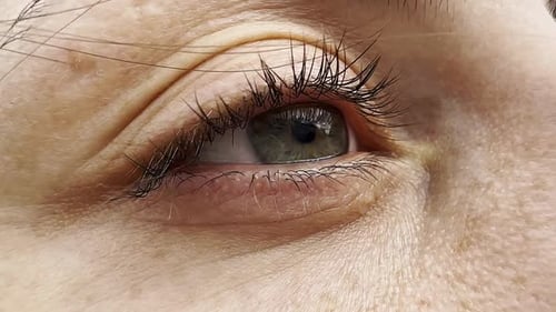 Focus on Right Green Eye of Attractive Girl Blinking and Looking Up Female Pretty Face Illuminating