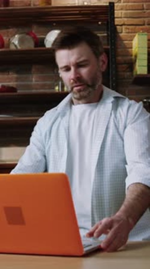 Man Opens Laptop in Kitchen