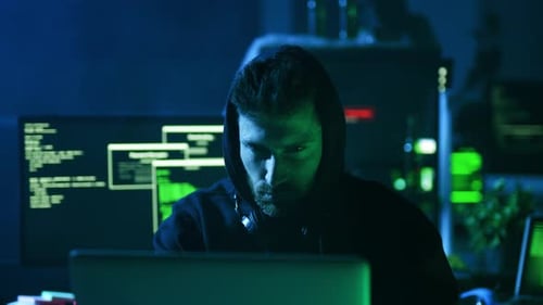 A Focused Hacker Engaged in Their Work Within a Dimly Lit and Mysterious Environment