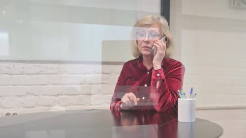 Senior Woman Talking on Cellphone in Office