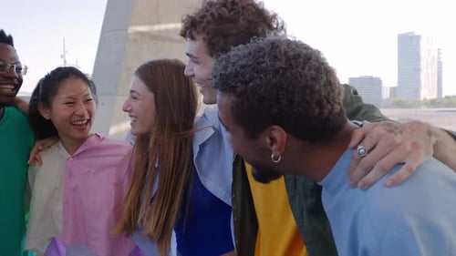 Grupo feliz de jovens se abraçando rindo ao ar livre