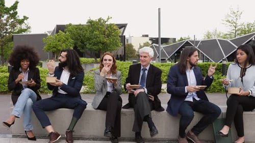 Multiracial business people with different ages having a lunch break outside office