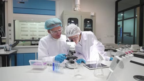 Scientists in Lab Coats Working With Microscope
