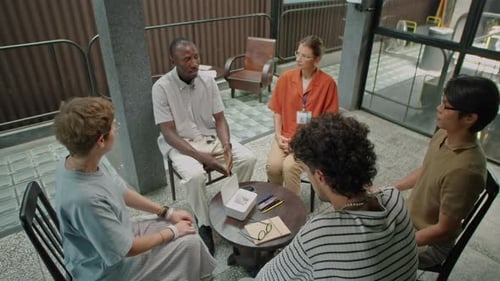 Five Adults Seated at Meeting Around Table
