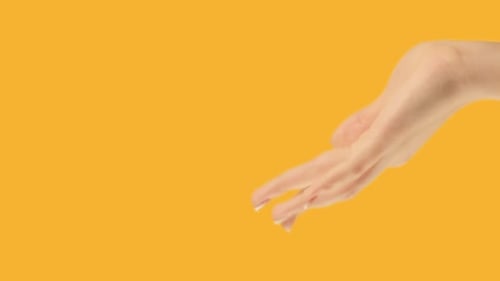 Woman's Hand Making Gestures on Yellow Background