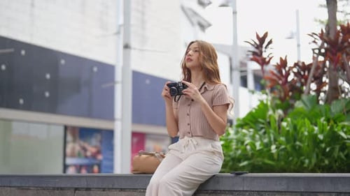 Asian woman traveler use camera taking a photo while traveling in city.