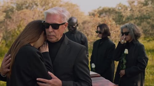 Senior Father Commiserating with Young Daughter at Funerals