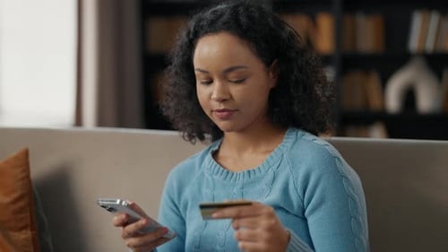 African American Woman Doing Online Payment Young Girl Buys in Internet on Smartphone Using Credit