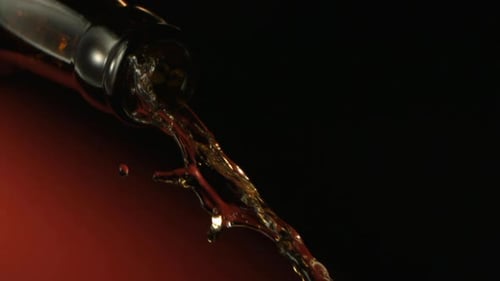 Alcohol Is Pouring Down From A Bottle Neck In Slow Motion On Dark Background Shot In Studio